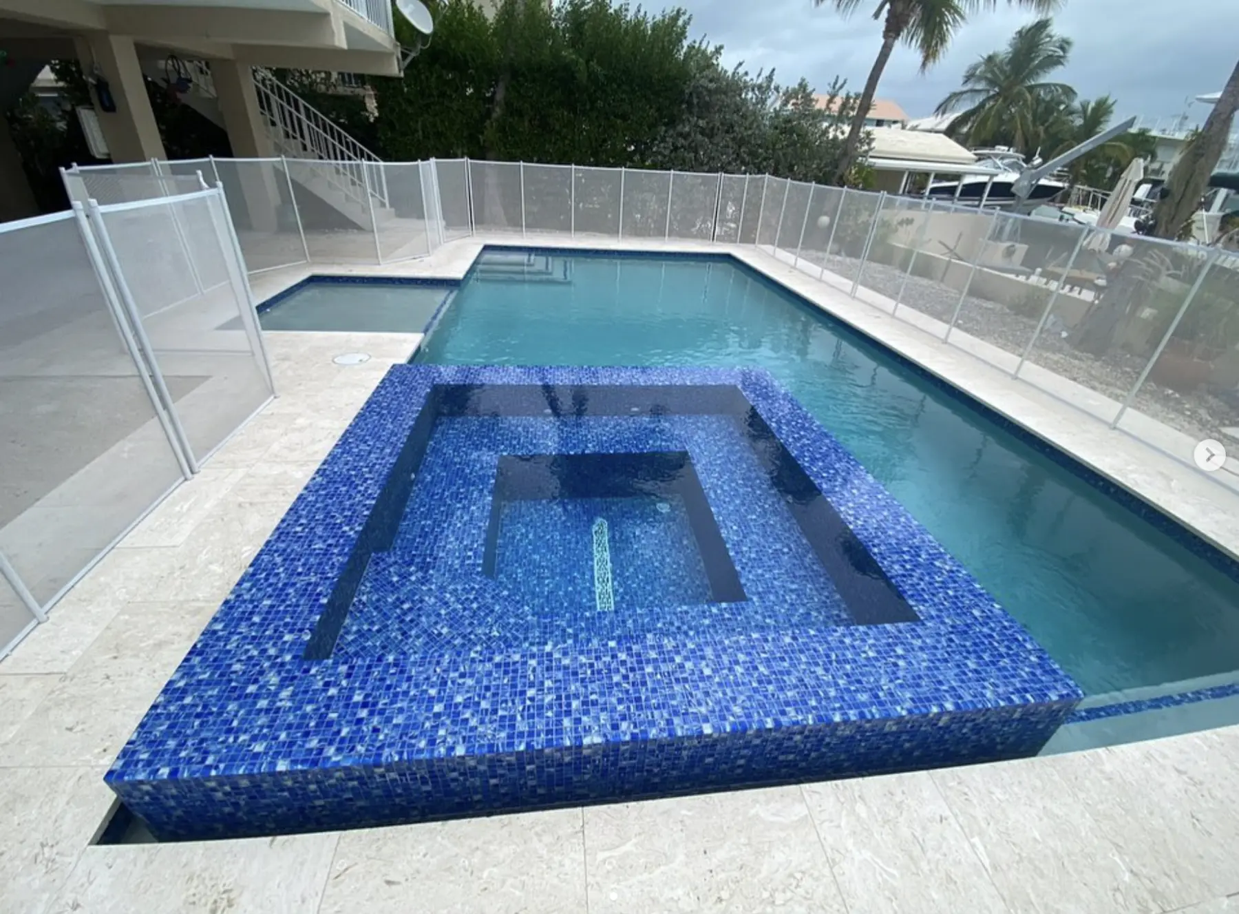 Custom raised spa flowing into pool